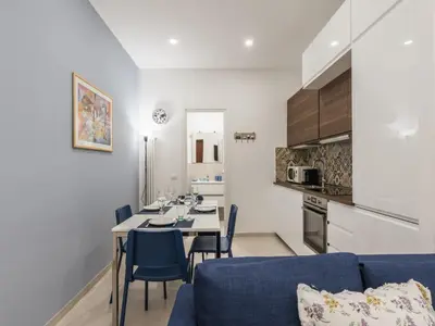 a living room with a table and a blue couch at The Best Rent - Two-bedroom apartment close to San Pietro in Rome