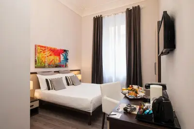 a hotel room with a bed and a desk with a television at Arenula Suites in Rome