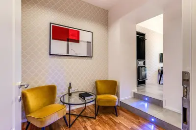 a living room with two chairs and a glass table at Arenula Suites in Rome