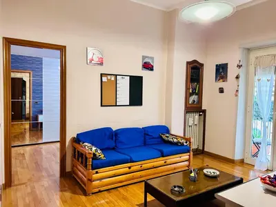 a living room with a blue couch and a table at Un piacevole alloggio turistico in Rome