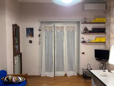 a living room with a large window with curtains at Un piacevole alloggio turistico in Rome
