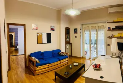 a living room with a blue couch and a table at Un piacevole alloggio turistico in Rome