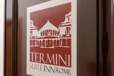 a poster of the colosseum on a wine bottle at Termini Suite Inn Rome in Rome