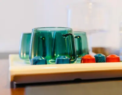 a green glass vase sitting on top of a table at Termini Suite Inn Rome in Rome
