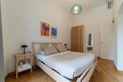 a bedroom with a white bed and a wooden floor at Magnolia terrace at Vatican Museum in Rome