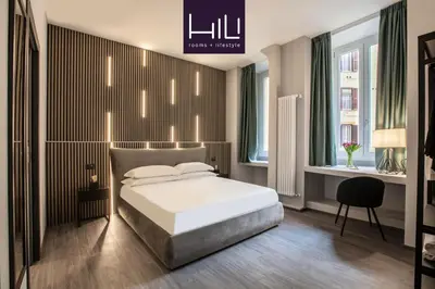 a bedroom with a bed and a desk and windows at Residenza Sacconi by Hili in Rome