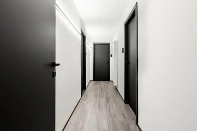 a hallway with black and white doors and wooden floors at Residenza Sacconi by Hili in Rome