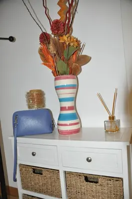 a colorful vase sitting on top of a dresser at Mary's House in Rome