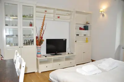 a living room with a television and white cabinets at Mary's House in Rome