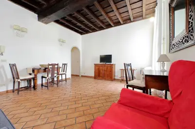 a living room with a red couch and a table at suity I cozy coronari apartment in Rome