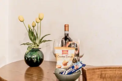 a bottle of wine and a vase with flowers on a table at PANTHEON allo SCRIGNO in Rome