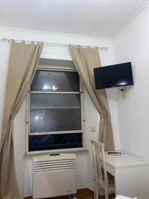 a room with a window with a desk and a television at Residenza in Rome