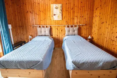 two beds in a room with wooden walls at Yourquadrarooms B&b in Rome