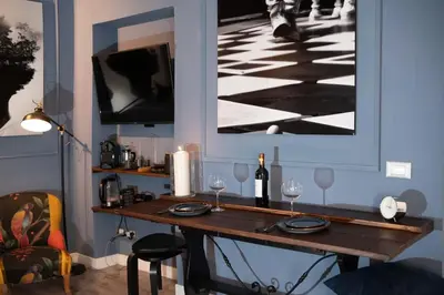 a table with wine glasses and a picture on the wall at Loft stupendo nel cuore di Trastevere AcasadiCri in Rome