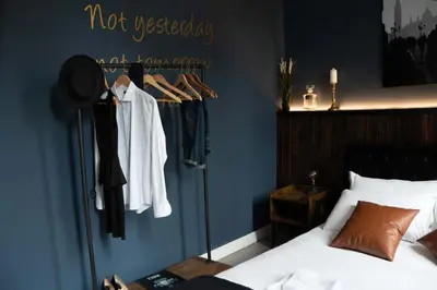 a bedroom with a bed and a rack of clothes at Loft stupendo nel cuore di Trastevere AcasadiCri in Rome
