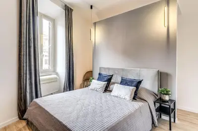 a bedroom with a large bed with blue pillows at Vatican Charming Home in Rome