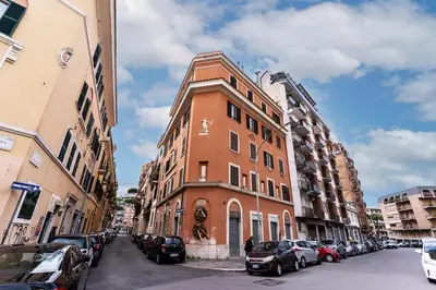 a tall brick building on a city street with parked cars at Vatican Charming Home in Rome
