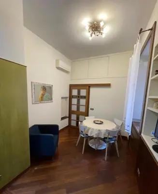 a living room with a table and a blue chair at Colosseum Street in Rome