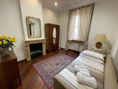 a bedroom with a bed and a mirror and a fireplace at Colosseum Street in Rome