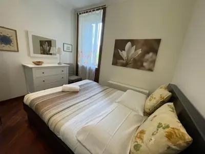a bedroom with a large bed with a dresser and a window at Colosseum Street in Rome