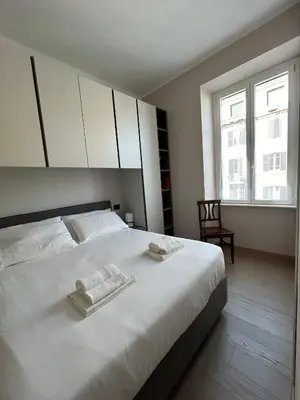 a bedroom with a large white bed with towels on it at Leonard Vatican House in Rome