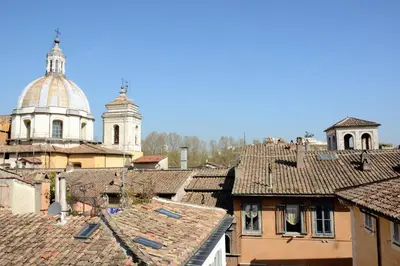 a view of roofs of a city with a cathedral at coronari apartments 2 in Rome