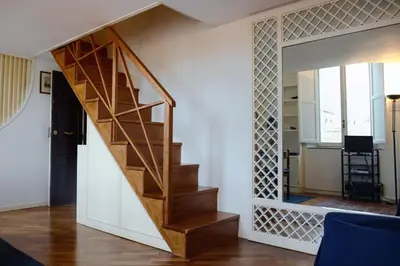 a wooden staircase in a living room with a mirror at coronari apartments 2 in Rome