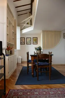 a dining room with a table and chairs and a kitchen at coronari apartments 2 in Rome