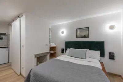 a bedroom with a large bed with a green headboard at GuestHost - Comfy Studio x2 - Trastevere District! in Rome