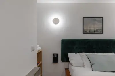 a white bed with a green headboard in a room at GuestHost - Comfy Studio x2 - Trastevere District! in Rome