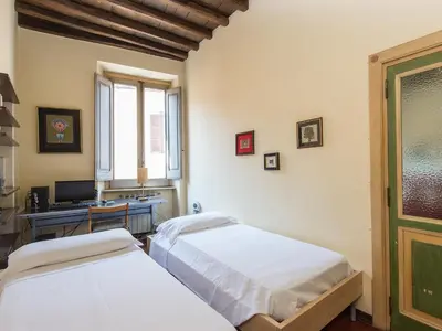 a bedroom with two beds and a desk with a computer at Apartment Navona by Interhome in Rome