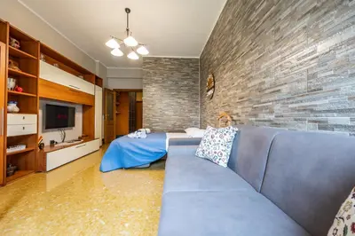 a living room with a blue couch and a brick wall at Big Apartment Rome Air Conditioning WIFI Netflix 90 MQ in Rome