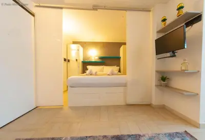 a small bedroom with a bed and a flat screen tv at Algima Flat Roma Ponte Milvio in Rome