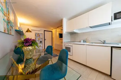 a kitchen with a glass table and blue chairs at Algima Flat Roma Ponte Milvio in Rome