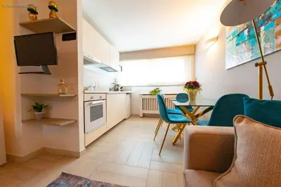 a kitchen and a living room with a table and chairs at Algima Flat Roma Ponte Milvio in Rome