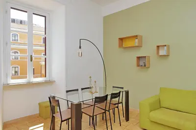a dining room with a glass table and a green couch at Luxury Vatican White House in Rome