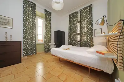 a bedroom with a bed and two windows with curtains at Luxury Vatican White House in Rome