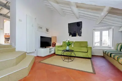 a living room with a green couch and a television at Monti Charme - My Extra Home in Rome