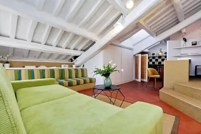 a living room with two green couches and a table at Monti Charme - My Extra Home in Rome