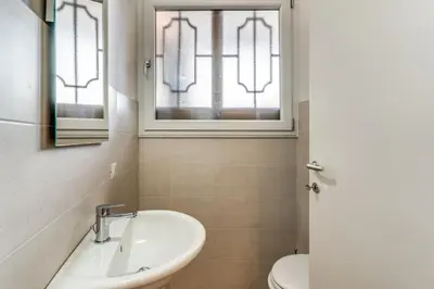 a bathroom with a sink and a toilet and a window at V E N E R E Apartments in Rome