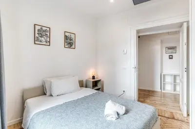 a white bedroom with a bed with a blue blanket at V E N E R E Apartments in Rome