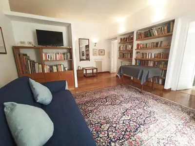 a living room with a blue couch and book shelves at Quiet ApartmentTrastevere in Rome