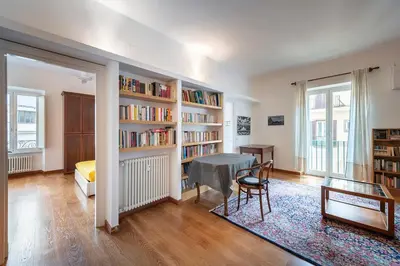 a living room with a table and book shelves at Quiet ApartmentTrastevere in Rome
