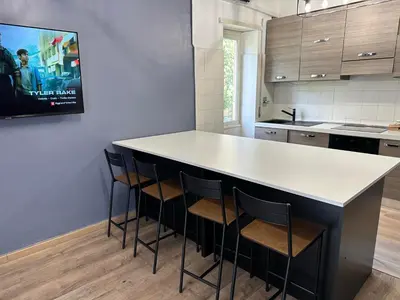 a kitchen with a white counter and stools at Roma Chic Flats Policlinico Gemelli in Rome