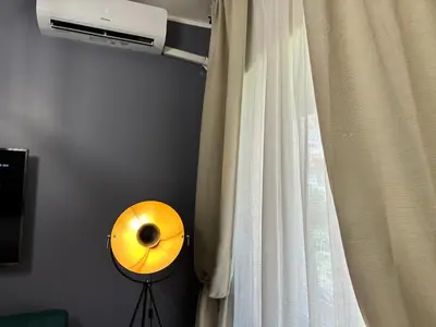 a yellow fan next to a window with a curtain at Roma Chic Flats Policlinico Gemelli in Rome