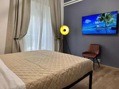 a bedroom with a bed and a lamp and a window at Roma Chic Flats Policlinico Gemelli in Rome
