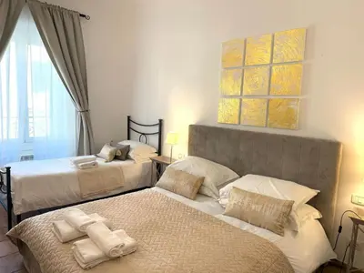a bedroom with two beds and a painting on the wall at Aenea's B&B in Rome