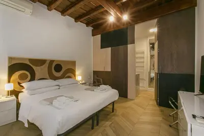 a bedroom with a large white bed and a bathroom at Trevi Little Palace #3 in Rome