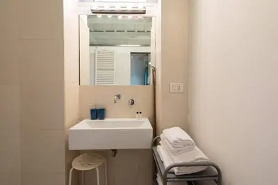 a bathroom with a white sink and a mirror at Trastevere Lovely Apartment in Rome