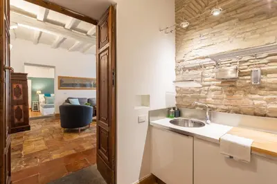 a kitchen with a sink and a stone wall at Trastevere Lovely Apartment in Rome
